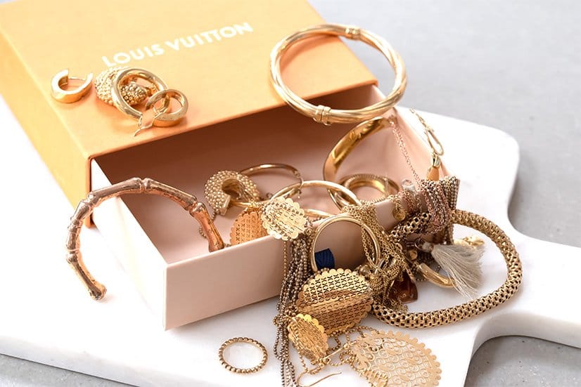 Doos met gouden sieraden op een witte ondergrond