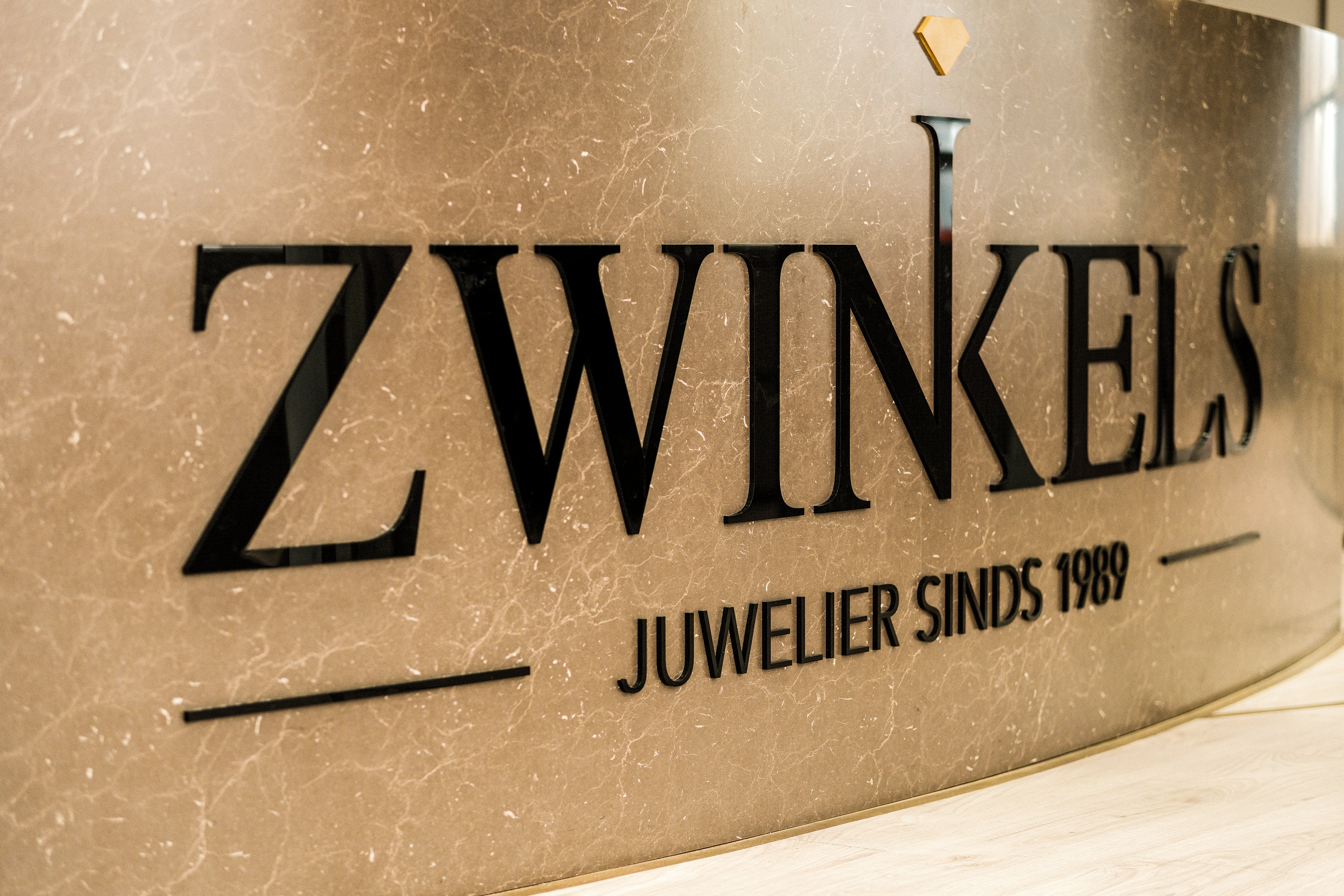 Zwinkels juwelier logo op marmeren balie met de tekst 'Juwelier sinds 1989'